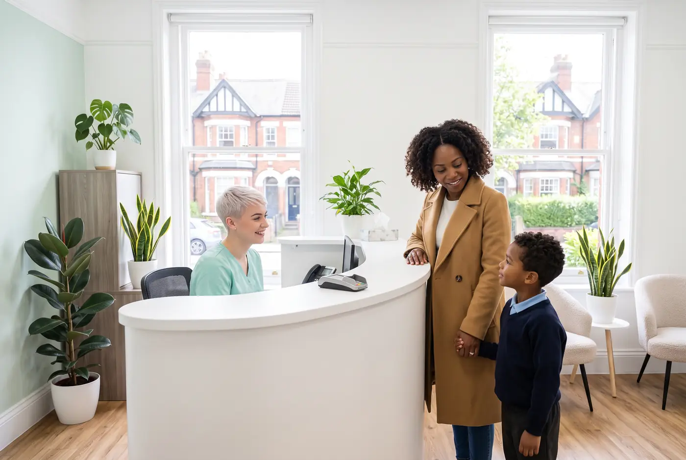 Receptionist greeting a mother and her young son at the front desk